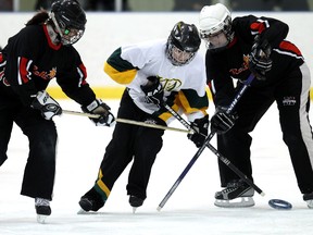 University of Alberta’s Shannon Jelec, centre, tries to break free of Edmonton Relit defenders Kelly Thomsen, left, and Shelley Derewianka during last weekend’s Finning Silver Ring ringette tournament at the Terwillegar Community Rec Centre. DAVID BLOOM QMI Agency