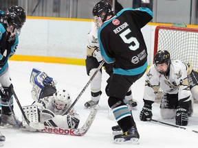 Quinte West Major Midget Hawks goalie Kevin Valdes pounces on a loose puck amongst a trio of Lindsay Muskies during the Hawks' 6-2 win Saturday at the Community Gardens.