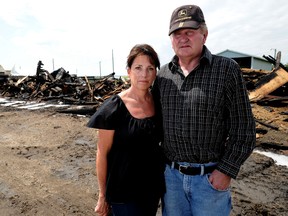 Ruth (L) and Larry Hixt stand in front of the charred remains of several buildings that were burned to the ground after being struck by lightning Friday evening SE of Beiseker , Alberta on July 28,2012 .  The buildings were part of the Grand'ole west Villa Ranche that consists of numerous old western style buildings, and props, some of which appeared in movies like Brokeback Mountain and Legends of the fall. The Hixt family had been working on and adding to the buildings since the 1970's.
 STUART DRYDEN/CALGARY SUN/QMI AGENCY