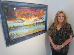 Petrolia painter Karen Benusik shows off some of her art at Gallery in the Grove Sunday. She and fellow painter Lisa Matlovich opened their joint exhibit at the gallery this past weekend. It runs until Feb. 23. PAUL MORDEN / THE OBSERVER / QMI AGENCY