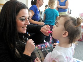 Jenna Larocque, left, helps Jayce-Lynne Primeau with the dress-up lipstick bought by Larocque and her sister Janette Cameron. Cameron, of London, organized a fundraising dance for the Primeau family who lost everything in a fire in January 2012. PHOTO TAKEN Chatham, on Tuesday February 05, 2013. DIANA MARTIN/ THE CHATHAM DAILY NEWS/ QMI AGENCY