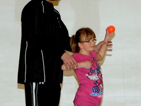 Mike Johnson, a former Major League Baseball player who is from Alberta, teaches Grade 7 student Megan Laurin some throwing techniques on Tuesday. (Patrick Callan/Daily Herald-Tribune)