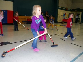 Addison Barash learns how to handle a broom Wednesday at Msgr. Morrison Catholic School where students were being introduced this week to curling. Addison is a senior kindergarten student at the school. (Eric Bunnell, Times-Journal)