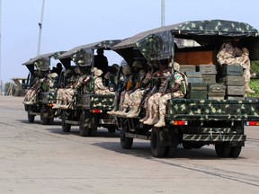 Nigerian soldiers sit in military trucks at the airport in Nigeria’s northern state of Kaduna before leaving for Mali on Jan. 17. When French and Malian forces eventually put down the rebellion, writes columnist Geoffrey Johnston, Ottawa and Washington should redouble their efforts to stabilize the region through closer political, economic and security co-operation.