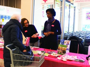 Regional Outreach Manager Maureen Owens shows an education pamphlet to a woman while volunteer Delnora Rice looks on during the Heart and Stroke Month kick off held at Portage Co-op, Thursday. (ROBIN DUDGEON/PORTAGE DAILY GRAPHIC/QMI AGENCY)