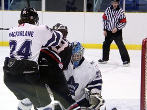 London Nationals goalie Taylor Edwards makes a pad save with Sarnia Legionnaires forward Derek D'Andrea (in black) fighting off Nationals defenceman Robert MacFarlane in the crease during the first period Thurdsay, Feb. 7, 2013 at Sarnia Arena in Sarnia, Ont. PAUL OWEN/THE OBSERVER/QMI AGENCY