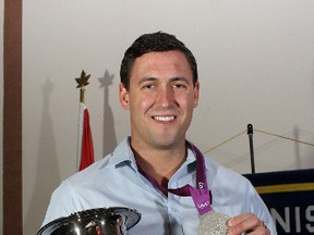 Rob Gibson, a 2012 Olympic silver medal-winning rower on Canada’s men’s eight crew, shows off his medal and the Gus Marker Trophy at the Kiwanis Athlete of the Year awards banquet Thursday night at the Ambassador Conference Resort. Gibson shared the award with crewmate Will Crothers, who could not attend because he’s in Western Canada training with the national team. (Ian MacAlpine/The Whig-Standard)
