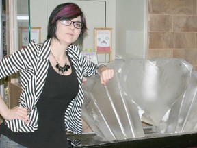 Jaclyn Gillier, manager of marketing for the Downtown Chatham Centre, poses on Feb. 8 with a heart-shaped ice sculpture created by Brian Machado. The ice sculputure is at the mall just outide Charm Diamond Centre. For $2 people can make a guess as to when a $1,200 pair of diamond earrings from Charm will be exposed. The person with the best guess wins the earrings. Proceeds go to the Heart and Stroke Foundation.
