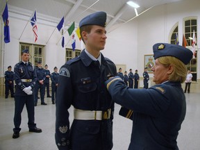 Air Cadet 741 Squadron warrant officer Ryan Reid receives his Duke of Edinburgh Award gold level pin Wednesday from commanding officer Anna Podebry. Reid is the first cadet in the squadron's history to reach the gold level of the international award. Nick Lypaczewski Times-Journal