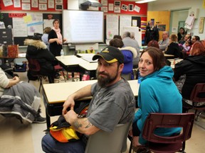 Hey, you two in the back! Parents Kevin Guerin and Crystal Gamache momentarily take their attention away from St. Paul School math intervention teacher Cristina Corbett (in the background) during Family Math Day. Corbett explained the various ways that St. Paul staff teach math and offered advice on how to make math fun and useful for kids.