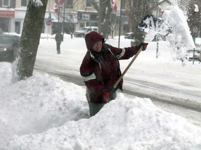 Photo lab owner Maureen Little shovels a path in front of her shop on Mechanic Street in Paris, Ontario for the third time on Friday, Feb. 8, 2013. An estimated 30 cm of snow fell on the town. MICHAEL PEELING/The Paris Star