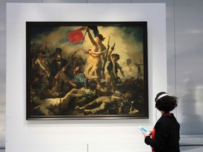 A woman looks at Eugene Delacroix's painting, "Liberty Leading the People" in this December 3, 2012 file picture. (REUTERS/Pascal Rossignol/Files)