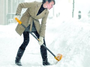 Carly Wilson keeps up with a nearly hourly task of shovelling in front of Earthwinds during the ongoing snowstorm Friday in Stratford. (SCOTT WISHART, The Beacon Herald)