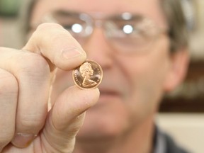 Wayne Bresee, owner of Maple Leaf Coins, holds a penny, a coin he says won't be disappearing from use anytime soon. 
Elliot Ferguson The Whig-Standard