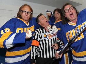 The Hanson Brothers, from left, Dave Hanson, Steve Carlson and Jeff Carlson, ham it up with former NHL referee Kerry Fraser in Calgary in September 2011. (QMI Agency file photo)