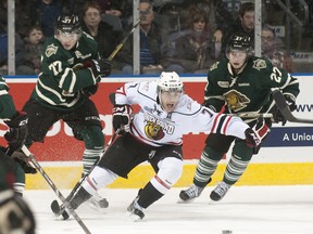 Owen Sound Attack forward Daniel Catenacci yells while beating London Knights players Josh Anderson, left, and Brett Welychka, right, to the puck Friday in London.