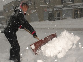 Marcy Michener, owner of the Simcoe Health and Fitness Centre in downtown Simcoe shovelled snow in front of her business during Friday morning’s storm. (DANIEL R. PEARCE Simcoe Reformer)