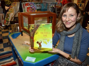 Elly MacKay with her first children's book If You Hold A Seed, which she authored and illustrated, at a launch at The Rocking Horse in downtown Owen Sound on Saturday. MacKay did a reading of the book and signed copies for those who purchased them.