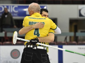 Craig Savill gives Glenn Howard a big hug after winning the Ontario men's curling championship in Barrie, Sunday. (Mark Wanzel/QMI Agency)