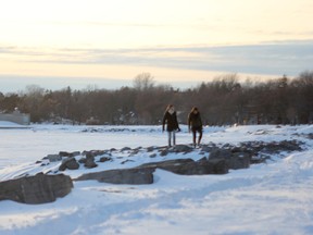People walk near Breakwater Park, along the shoreline of Lake Ontario. (Whig-Standard file photo)