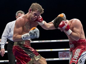 Kingston's Tyler Asselstine, left, exchanges punches with Baha Laham during their junior lightweight bout Friday night at the Bell Centre in Montreal. Laham handed Asselstine his first career loss. (QMI Agency)