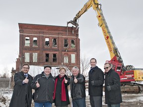 (From left) Mayor Chris Friel, city councillors Dave Neumann, Marguerite Ceschi-Smith, John Utley, manager of policy and planning Paul Moore, and ProGreen Demolition general manager Joe Batista give the thumbs up on Monday as demolition gets underway at the 66 Mohawk Street brownfield site. (BRIAN THOMPSON The Expositor)