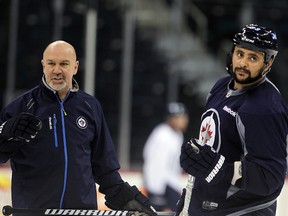 Winnipeg Jets defenceman Dustin Byfuglien (right) looks back at players while listening to assistant coach Charlie Huddy during an optional practice in Winnipeg, Man. Sunday Feb. 10, 2013. (BRIAN DONOGH/Winnipeg Sun)