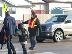 Angie Eigler, the new crossing guard at St. Mary School, stops traffic for some pedestrians on Feb. 6.
Barry Kerton | Whitecourt Star