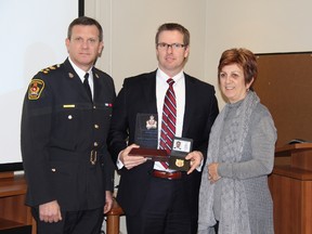 Chatham-Kent Insp. Trevor Crane, middle, displays his inspector's badge and a police services board citation presented in Chatham, Ontario on Monday February 11, 2013. Chatham-Kent police Chief Dennis Poole, left, and board acting chair Diane Daly congratulated Crane for his professionalism and dedication to the job. VICKI GOUGH/ THE CHATHAM DAILY NEWS/ QMI AGENCY