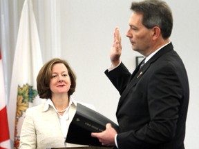 Premier Alison Redford watches Richard Starke during swearing in ceremony at Government House in Edmonton, Alberta on Feb 8, 2013.