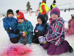 Working together to create a bright splash of colour in the snow on the Elmer Elson Elementary School playground on Tuesday, Feb. 5, are kindergarten students, from left, Caleb Bussche, Dirk Pas, Gabriel Belanger and Shayla Hjemeland.