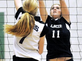 Ursuline Lancers' Brooke Smith (11) tries to block Chatham Christian Flames' Amy Bultje in a semifinal Saturday at the UCC Team Varsity Sports senior girls volleyball tournament at Ursuline College Chatham. Ursuline swept Sault Ste. Marie Korah 25-22, 25-13 in the final after beating Chatham Christian 18-25, 25-21, 15-7 in a semifinal. (MARK MALONE/The Daily News)