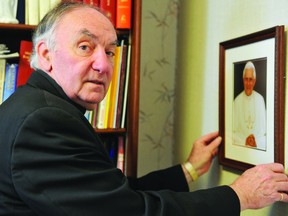 Father Brian Price adjusts a portrait of Pope Benedict XVI at St. Francis Xavier Catholic Church on Monday. RONALD ZAJAC The Recorder and Times