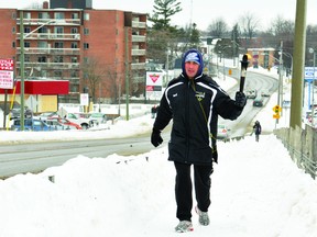 Frank Apuzzo carries the 'Torch of Life' over the William Street railway overpass Monday morning as he continues the 'Anthony's Hero' walk for live organ donation awareness through Brockville. RONALD ZAJAC The Recorder and Times