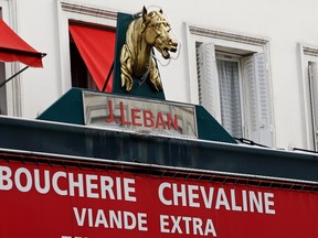 A metal horse head outlined with a neon light is seen above a horsemeat butcher shop in Paris in this February 11, 2013 file picture. (REUTERS/Charles Platiau)