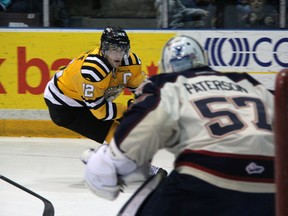Sarnia Sting captain Charlie Sarault, in yellow, cuts in on Saginaw Spirit goalie Jake Paterson in a recent game. Sarault, the OHL's leading scorer, is going head-to-head with Nick Cousins, the guy one point behind him, Wednesday when the Sting play Sault Ste. Marie. (PAUL OWEN, The Observer)