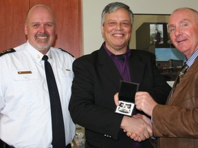 Const. Richard Losier, centre, who retired on Dec. 31 after 23 years of service with the Timmins Police Service, is presented with his retirement badge from Chief John Gauthier, left, and Timmins Mayor Tom Laughren. The presentation was made during Monday’s police services board meeting.