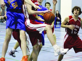 Jeanne-Lajoie's Gabriel Arsenault (centre) pushes past Bishop Smith's Toby Chapieski (left) during third quarter junior boys' basketball action. The Chevaliers downed the Crusaders 35-27.