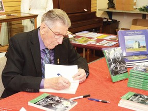 George Wilson signs a copy of his book – Memoirs of an Engineer – which he finished writing when he was 103 years old.
