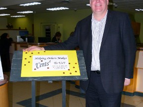 Mike Barter, manager of Fairview Servus Credit Union with the wishing well where you can drop off your unwanted pennies.