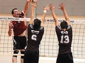 Wolves middle Jonathan Morley smashes past the Griffin wall of Trey Lidbury (6) and Tyler Lundgren. The Grande Prairie Regional College Wolves hosted the Grant MacEwan Griffins in ACAC men’s volleyball at GPRC gym last Friday. (Terry Farrell/Daily Herald-Tribune)