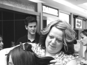 Michelle Scott, Regis Salon, trims what is left of Ilinca Georgescu's hair after her eight-inch donation at Students for Wishes Queen's University's Hair Raiser event, held February 9 at the Cataraqui Centre. The event featured participants cutting their hair, coloring their hair blue, or shaving their head in support of Make A Wish, which grants wishes to children with life threatening illnesses. “I feel great, actually,” said Georgescu, a fourth year student at Queen’s University. “It is a really great cause.”