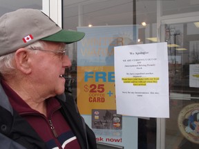 Less Hogg of Ridgetown reads a sign on the front door of the CAA office in Chatham, On. on February 14,2013 noting that the office is temporarily out of international driver's licence application forms. There was a big run on the forms Thursday by area residents heading to the Sunshine State. (Bob Boughner, Chatham Daily News)