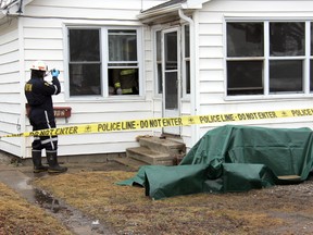 An inspector with the Ontario Fire Marshal takes pictures at a Sandys Street home in Chatham Ont. on Thursday Feb. 14, 2013. The fire occurred in the early morning hours. There were no injuries and the cause is yet to be determined. (TREVOR TERFLOTH, The Chatham Daily  News)