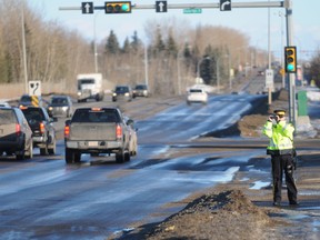 Cst. Jamie Day of the Grande Prairie RCMP keeps an eye out for distracted drivers and motorists not wearing their seatbelts at the Fas Gas on 84 Avenue, Wednesday. The RCMP had a spotter located near the No Frills advising the waiting RCMP, Sheriff and Commercial Vehicle Enforcement officers of offenders. (Aaron HInks/Daily Herald-Tribune)