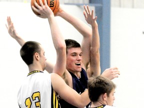 Chatham Christian Flames' Mike Ball grabs a rebound while surrounded by Patriotes' Eric Peltier (23), Andrew Woodall (14) and Luke Williams in the Kent 'A' senior boys basketball final Thursday at Pain Court. (MARK MALONE/The Daily News)