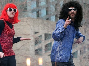 Caption this photo in the box below. Here is the real caption: Veronica Martens and Jon Paterson, from the National Stilt Walkers of Canada, dance their way through the crowd as they take part in the Valentine's Day Disco Skate event at the city hall skating rink in Edmonton, Alta. on Thursday, Feb. 14, 2013. (David Bloom/Edmonton Sun)