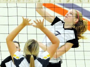 Chatham Christian Flames' Amy Bultje, right, hits over Pain Court Patriotes' Brooke Marchand during the Kent 'A' senior girls volleyball final Friday at Chatham Christian.(MARK MALONE/The Daily News)