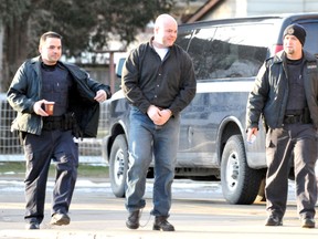 Convicted murderer Mason Jenkins, centre, is escorted by two unidentified Correctional Service Canada armed guards as he walks towards a funeral home to pay his last respects to his grandmother prior to her funeral in Chatham, Ontario on Saturday February 16, 2013. Jenkins, who is serving a life sentence for the first-degree murder of his sister in 1998, arrived in  handcuffs and shackles after being granted an escorted temporary absence by the Parole Board of Canada for compassionate reasons. VICKI GOUGH/ THE CHATHAM DAILY NEWS/ QMI AGENCY