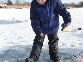 Ethan Klazinga, 8, of Wyoming, waits for a big catch at the Sarnia Bay Saturday. Beautiful weather and thick ice attracted one of the largest turnouts in recent memory to the annual Bluewater Anglers' ice fishing derby.